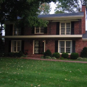 Before picture of porch remodel with old wrought iron rails