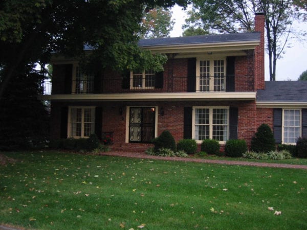 Before picture of porch remodel with old wrought iron rails