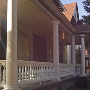 Front porch railing with Revival spindles and round tapered columns