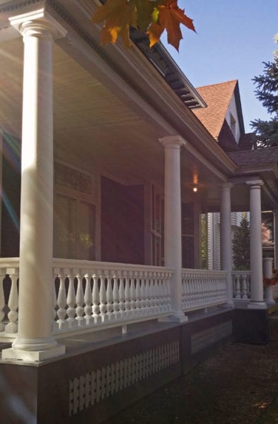 Front porch railing with Revival spindles and round tapered columns