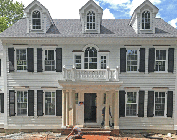 Federal style home with covered entry with railing